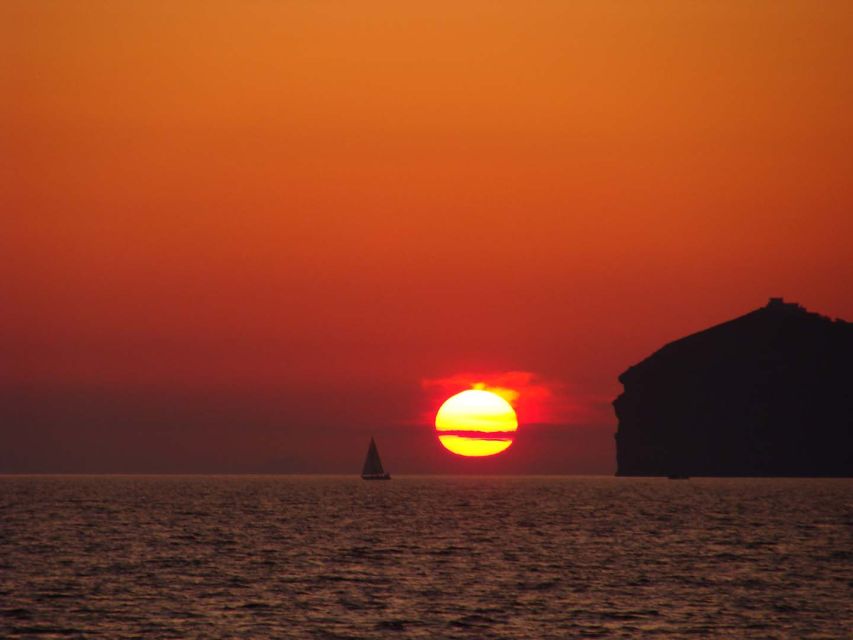 Santorini: Sunset Cruise with Greek Dinner and Transfer - Dinner arrives as the sun drops